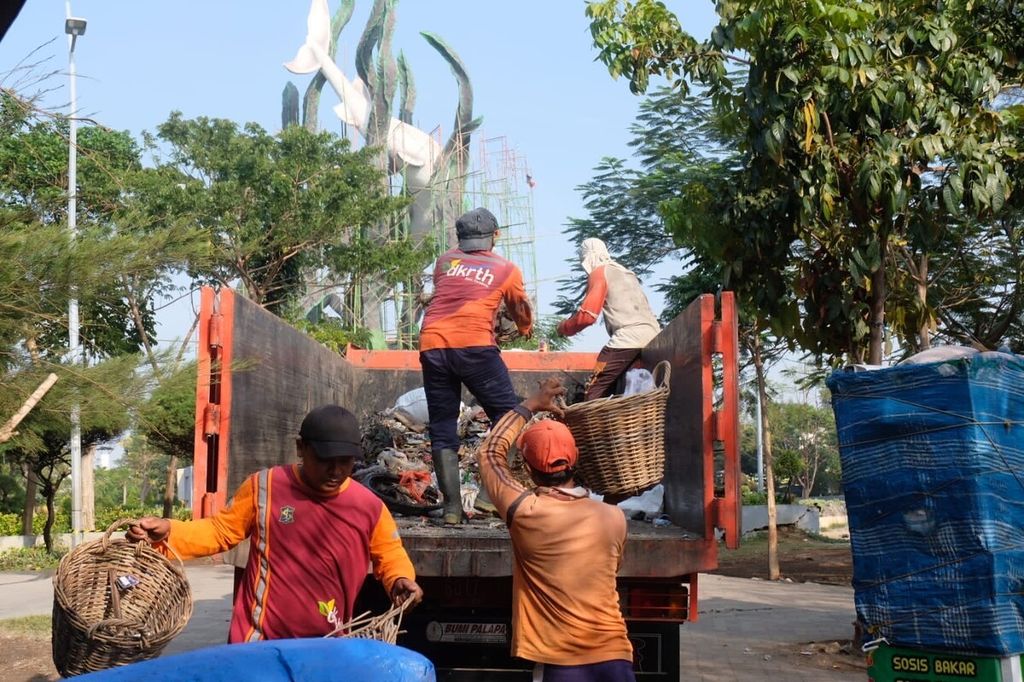 Petugas kebersihan dari Pemkot Surabaya sedang mengangkut hasil kerja bakti "Surabaya Bergerak" pada Minggu (13/11/2022).