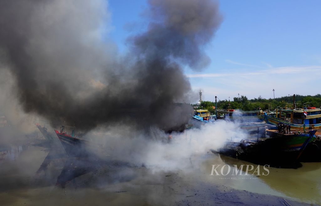 Sejumlah orang berupaya memadamkan api yang melalap kapal dengan peralatan seadanya di galangan kapal PT Tegal Shipyard Utama, Kelurahan Mintaragen, Kecamatan Tegal Timur, Kota Tegal, Jawa Tengah, Rabu (17/11/2021). 