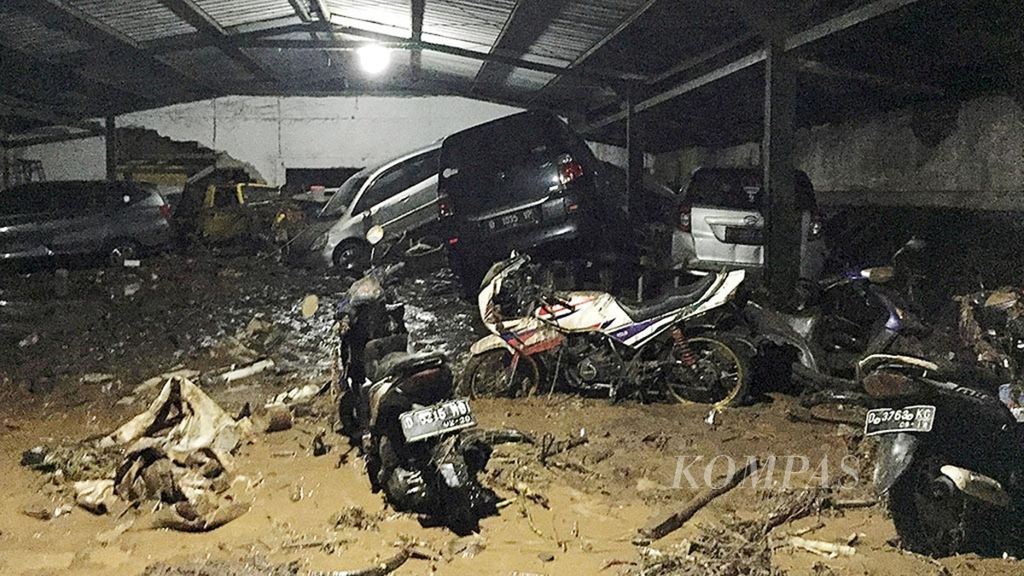 Sejumlah mobil rusak akibat terseret banjir bandang hingga posisinya berdempetan ke dinding belakang gedung parkir bersama di Jalan Ahmad Yani, Kota Bandung, Jawa Barat, Selasa (20/3/2018) sekitar pukul 15.30. 