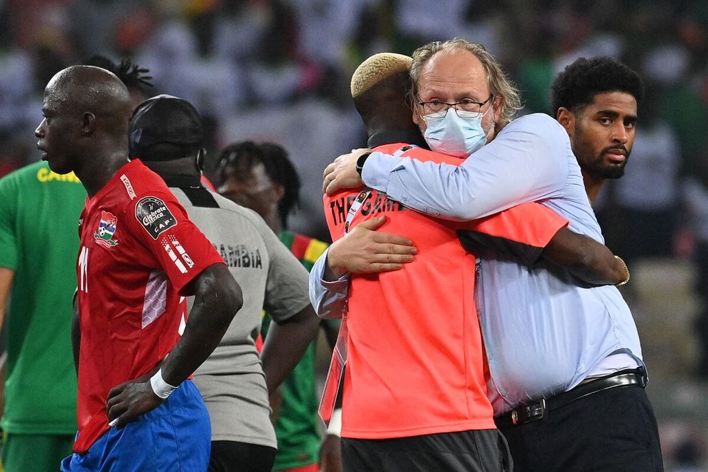 Pelatih Gambia Tom Saintfiet (kanan) memeluk pemainnya seusai laga versus Kamerun pada babak perempat final Piala Afrika 2021 di Stadion Japoma, Kamerun, Tuan rumah Kamerun menang, 2-0.