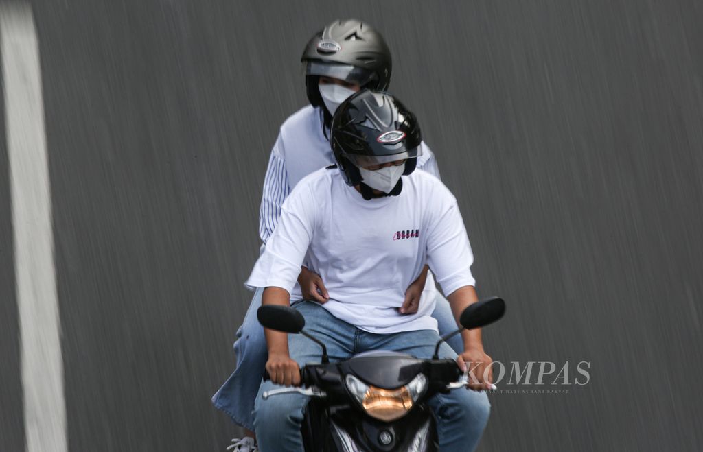 Pengendara sepeda motor mengenakan masker saat melaju di jalan protokol Jenderal Sudirman, Jakarta, Rabu (23/8/2023). Mayoritas sumber emisi penyebab pencemaran udara di Jabodetabek berasal dari aktivitas lokal, khususnya dari sektor transportasi. 