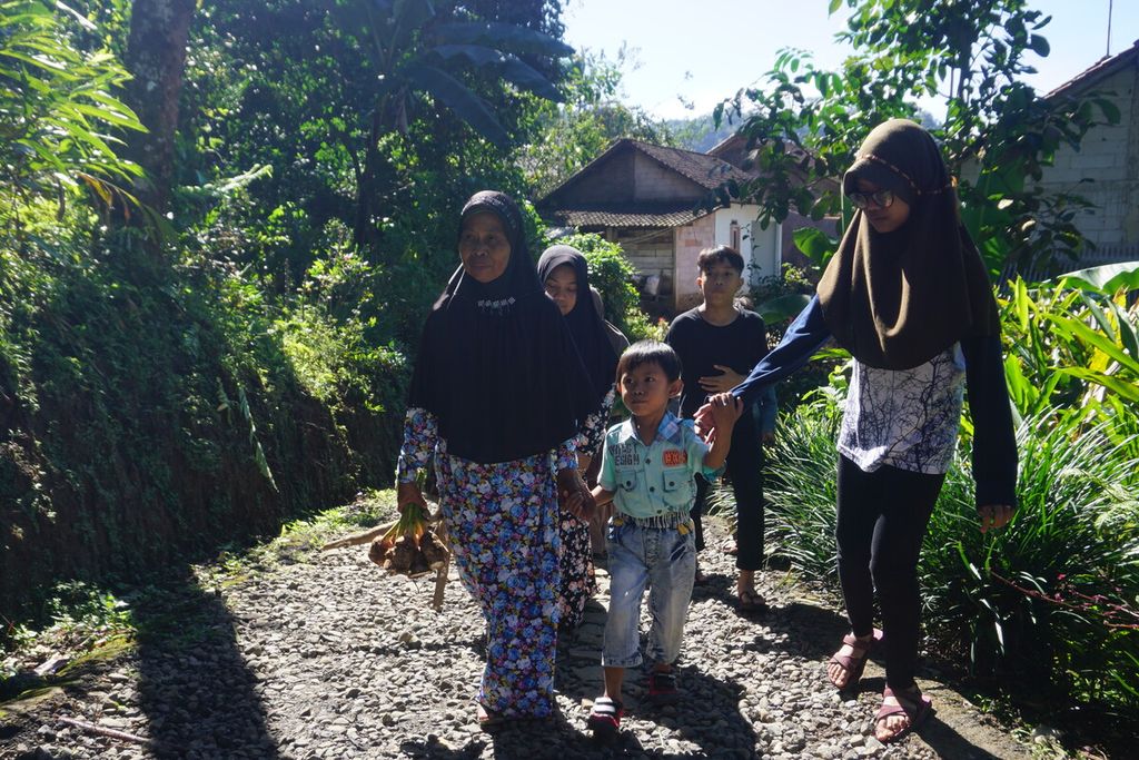 Suwarsiti menenteng talas untuk mendaftarkan cucunya sekolah di MTs Pakis di Desa Gununglurah, Cilongok, Banyumas, Jawa Tengah, Rabu (12/7/2023).