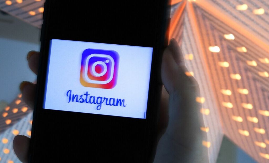Seorang pengguna telepon genggam cerdas memperlihatkan logo Instagram, salah satu platform media sosial terkenal, di Arlington, Virgnia, Amerika Serikat, September 2021. 
