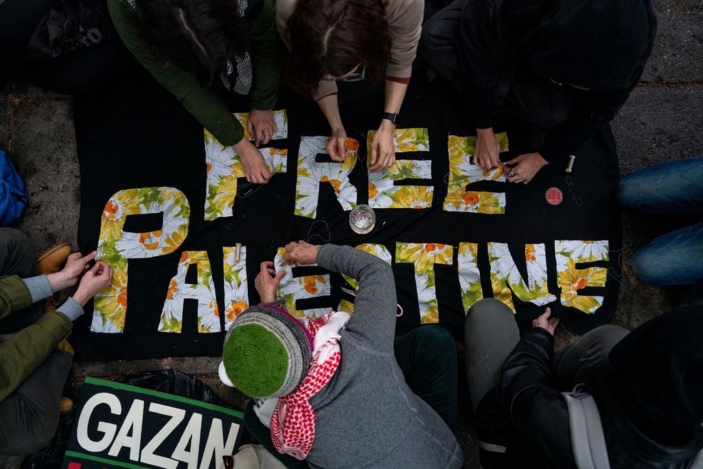 Para mahasiswa Universitas George Washington di Washington DC, Amerika Serikat, menulis pesan-pesan pro-Palestina dalam unjuk rasa pada 27 April 2024.  