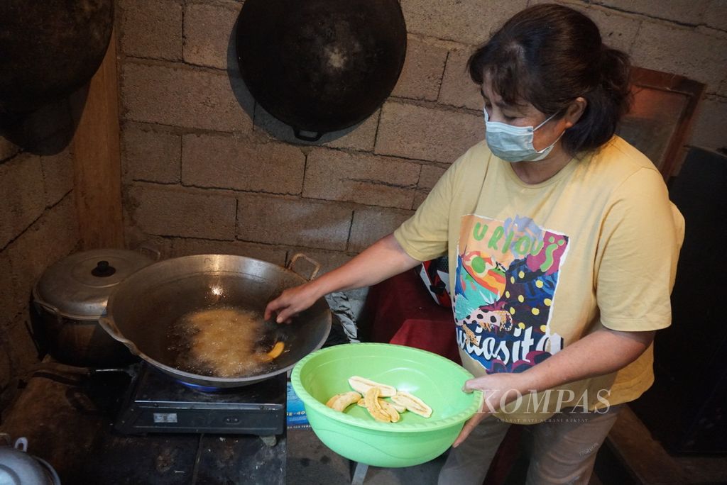 Yuli Dompas (57), warga Desa Tumaluntung, Minahasa Utara, Sulawesi Utara, memasak dengan kompor berbahan bakar biogas, Senin (4/7/2022).