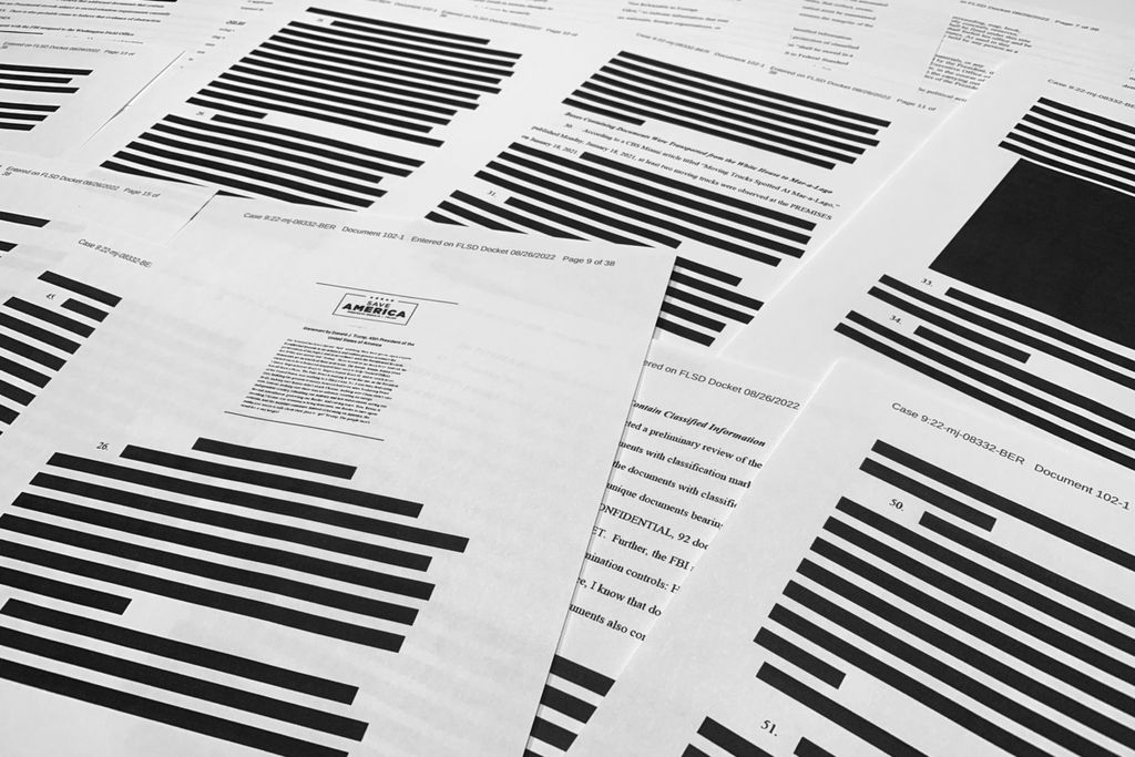 Beberapa halaman dokumen surat pernyataan (<i>affidavit</i>)  Biro Investigasi Federal AS (FBI) terlihat dicoret dengan tanda hitam saat difoto, Jumat (26/8/2022). Dokumen ini menjadi dasar penggeledahan rumah peristirahatan mantan Presiden AS Donald Trump oleh aparat keamanan AS yang ingin mencari dokumen-sokumen pemerintah. 