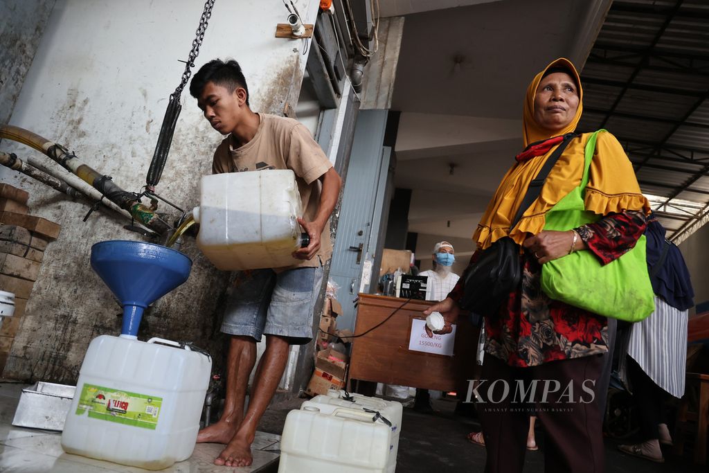 Pekerja melayani pembeli minyak goreng curah di salah satu penyalur di  Kabupaten Temanggung, Jawa Tengah, Kamis (14/4/2022). 