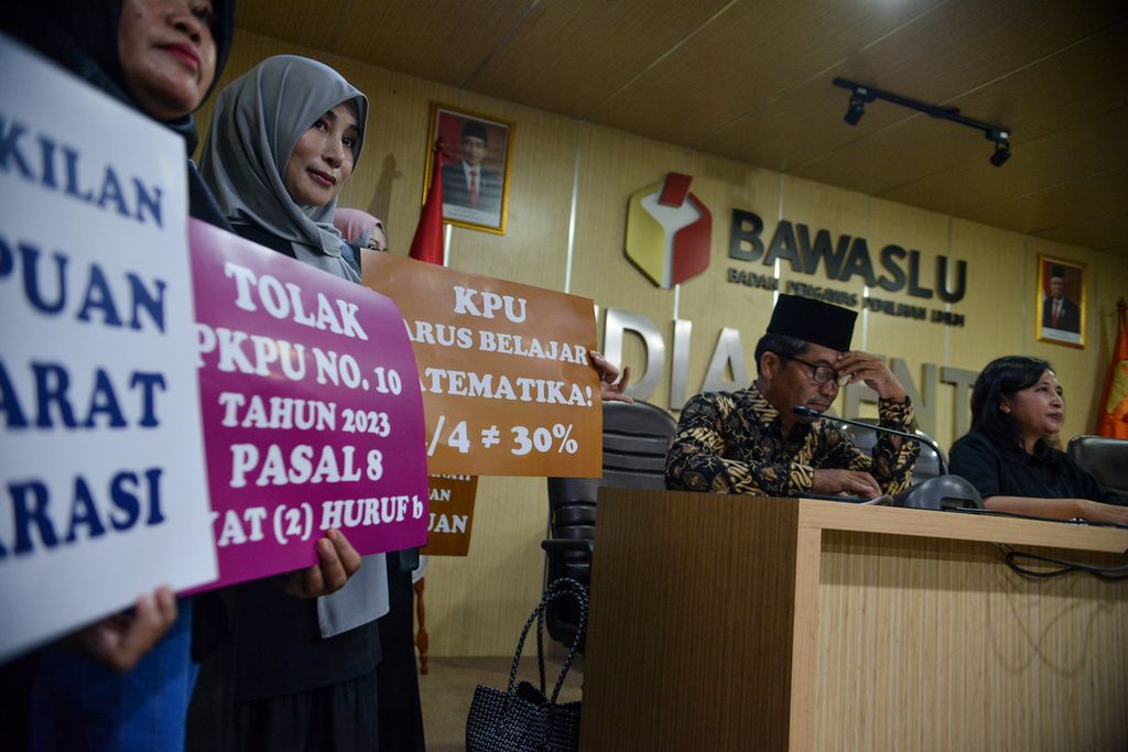 Peserta aksi membawa poster penolakan Peraturan Komisi Pemilihan Umum (PKPU) Nomor 10 Pasal 8 saat sesi konferensi pers di kompleks Badan Pengawas Pemilu (Bawaslu), Jakarta Pusat, Senin (8/4/2023). 