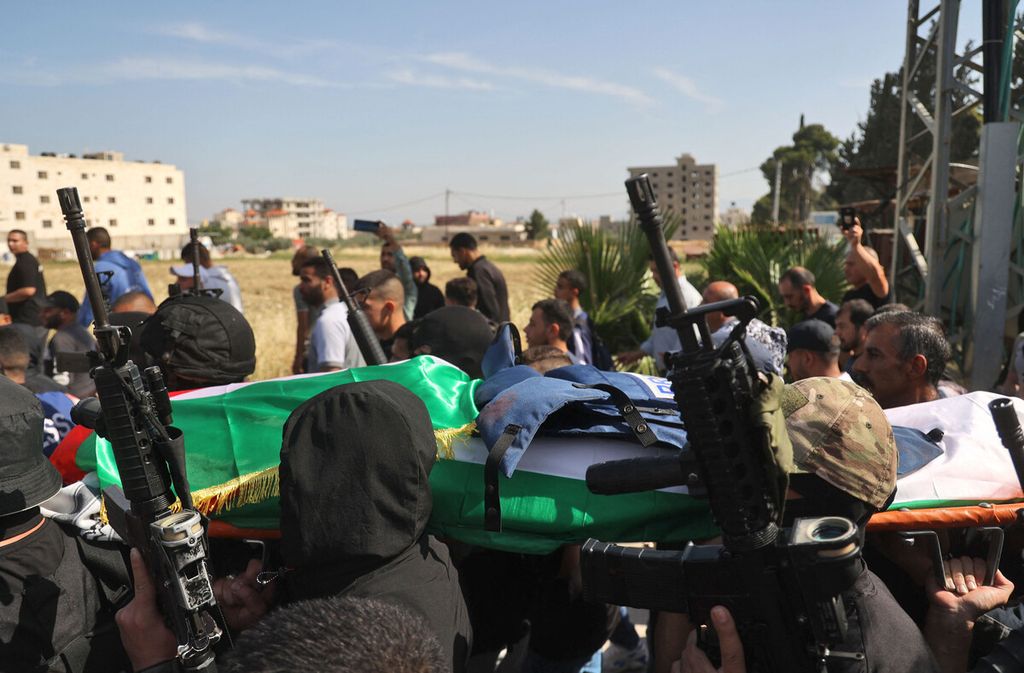 Arakan pelayat dan sekelompok pria bersenjata bertopeng membawa jenazah jurnalis veteran Al Jazeera Palestina Shireen Abu Akleh yang ditembak mati oleh pasukan Israel saat meliput serangan di kamp pengungsi Jenin di Tepi Barat, 
