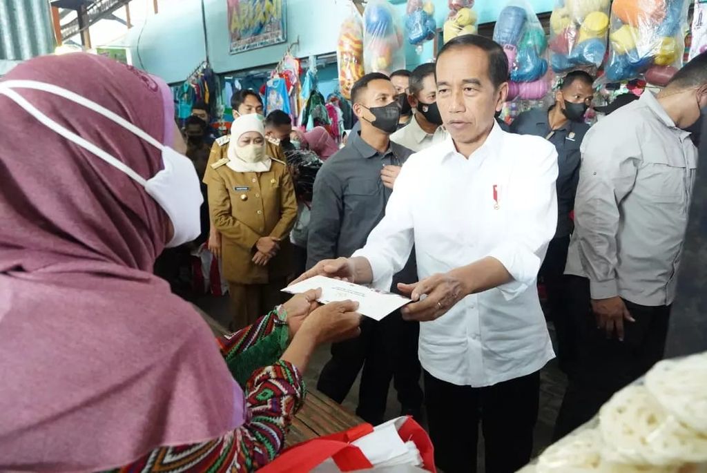 Presiden Joko Widodo menyerahkan bantuan modal kerja kepada pedagang di Pasar Sukolilo, Madiun, Jatim, Selasa (20/12/2022).