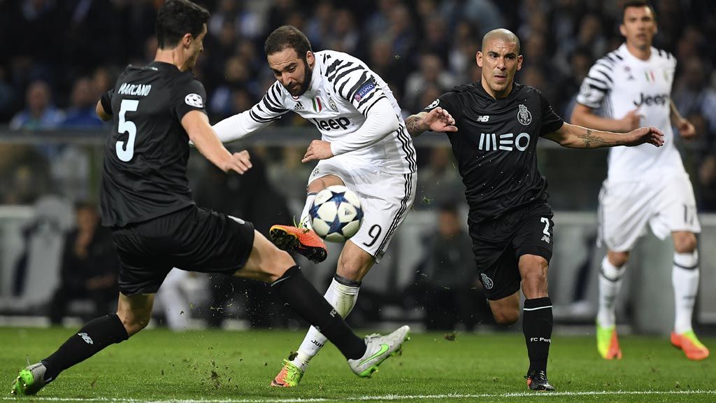 Striker Juventus  Gonzalo Higuain menendang bola melawati bek Porto Ivan Marcano  pada laga pertama babak 16 besar Liga Champions di Stadion Dragao, Porto, Kamis (23/2) dini hari WIB. Juventus berpeluang besar lolos ke perempat final berbekal kemenangan  2-0. 