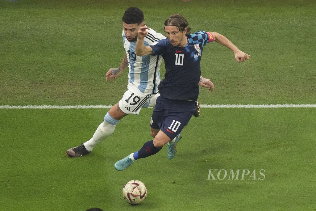 Pemain Argentina Nicolas Otamendi berebut bola dengan pemain Kroasia Luca Modric di babak semifinal Piala Dunia 2022 di Stadion Lusail, Qatar, Rabu (14/12/2022) dini hari WIB. Argentina melaju ke final Piala Dunia 2022 setelah mengalahkan Kroasia 3-0. 
