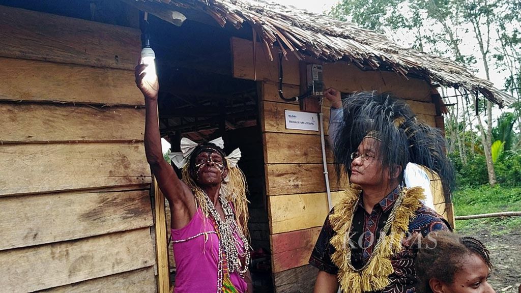 Salah satu warga yang baru pertama kali merasakan penerangan listrik di Kampung Enem, Kabupaten Mappi, Papua, Selasa (24/7/2018).
