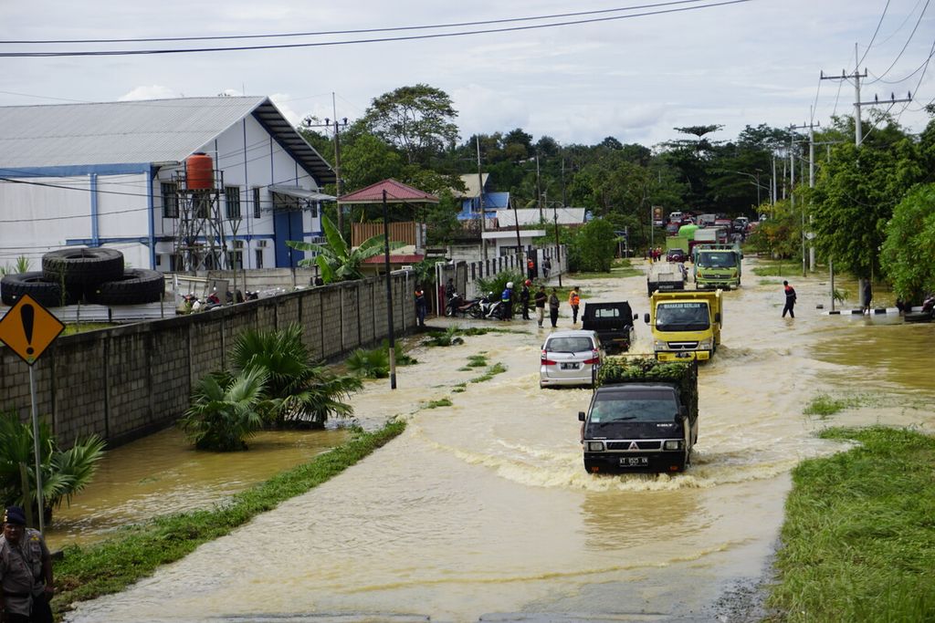 Mobil melintasi jalan yang terendam banjir setinggi sekitar 50 sentimeter menuju Pelabuhan Kariangau Balikpapan, Kalimantan Timur, Kamis (30/1/2020). Hujan sejak dini hari membuat lima RT atau 220 jiwa terendam banjir di Balikpapan Utara.