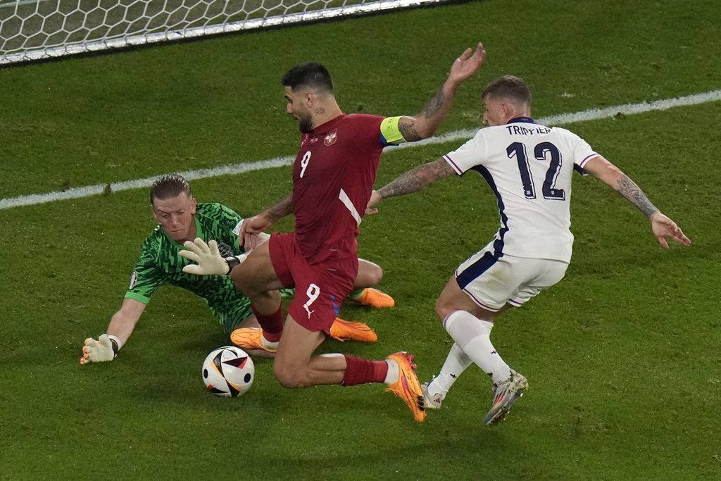 Kiper Inggris, Jordan Pickford (kiri), melakukan penyelamatan gawangnya dari serangan yang dilakukan oleh pemain Serbia, Aleksandar Mitrovic (tengah), dalam laga Grup C Piala Eropa 2024 yang digelar di Gelsenkirchen, Jerman, Senin (17/6/2024) dini hari WIB. 