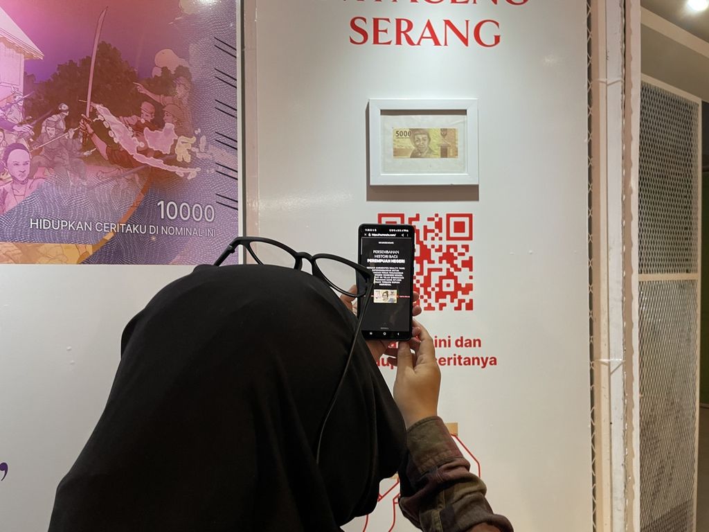 Pengunjung mencoba memindai kode batang untuk melihat pahlawan-pahlawan perempuan yang ada di nominal uang dalam pameran bertajuk Perempuan Kuat Ekonomi Bangsa Hebat yang diselenggarakan Bank OCBC NISP di Mall Sarinah Thamrin, Jakarta, Kamis (3/11/2022).