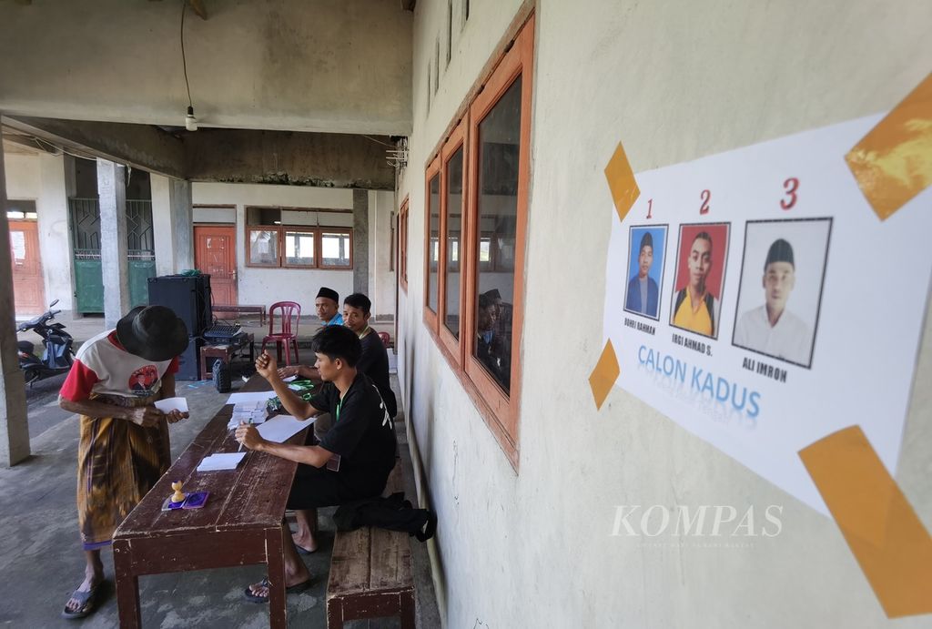 Panitia pemungutan suara menyerahkan surat suara kepada warga yang akan memilih kepala dusun di Madrasah Ibtidaiyah Nahdlatul Wathan Kwang Jukut, Desa Pringgarata, Kabupaten Lombok Tengah, Nusa Tenggara Barat, Sabtu (18/3/2023). Pemilihan terbuka secara langsung mengajarkan warga di dusun tersebut untuk berdemokrasi.