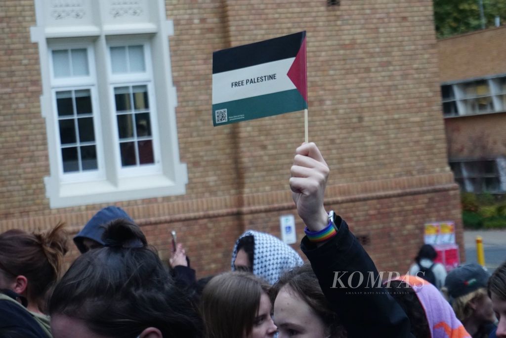 Mahasiswa mengangkat bendera Palestina ketika berjalan berarakan menuju gedung Rektorat Universitas Melbourne di kampus Parkville, Melbourne, Australia, Senin (29/4/2024). 