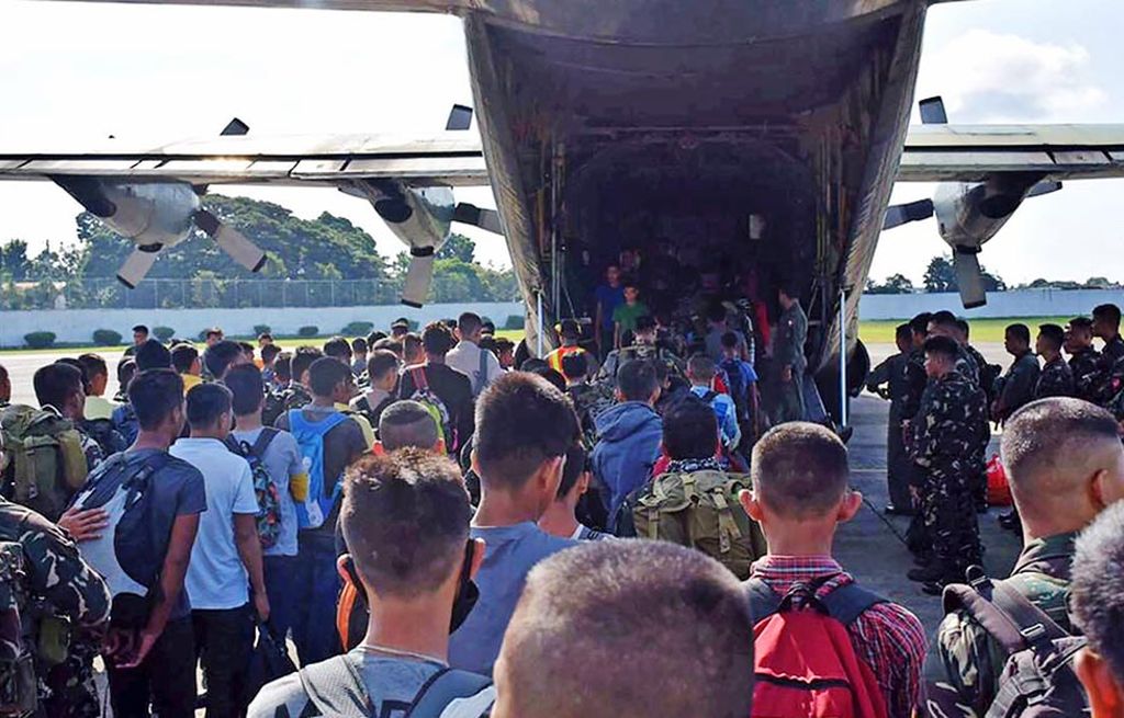 Dalam foto  yang dirilis di Filipina pada Jumat (28/7) ini,  para tersangka, yang ditangkap karena diduga hendak memperkuat milisi kelompok ekstrem di Marawi, bersiap untuk naik ke pesawat militer di Zamboanga, Pulau Mindanao, Filipina selatan.  Pasukan Filipina menyatakan telah menangkap 59 orang yang diduga hendak membantu kelompok ekstrem bertempur melawan pemerintah di Marawi. 