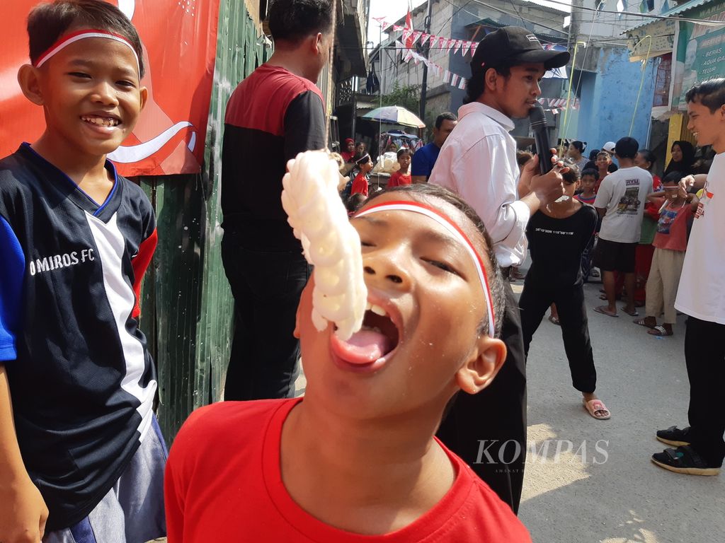 Anak-anak mengikuti lomba makan kerupuk di Muara Baru, Penjaringan, Jakarta Utara, pada Kamis (17/8/2023).