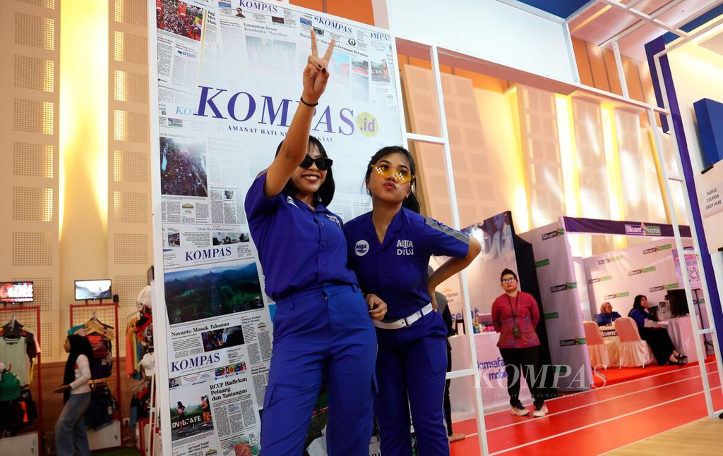 Pengunjung berfoto di stan harian <i>Kompas</i> saat pengambilan <i>race pack</i> atau perlengkapan lomba Borobudur Marathon 2023 di Hotel Artos, Kota Magelang, Jawa Tengah, Jumat (17/11/2023). 