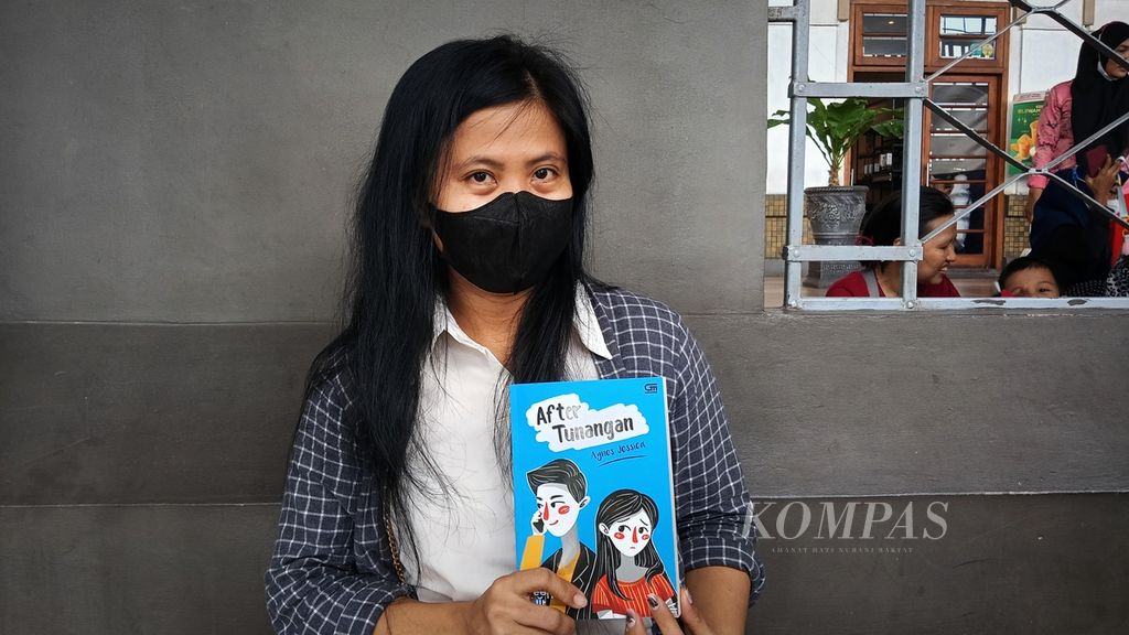 Karsiani (39), warga Depok, menyempatkan mampir untuk membaca buku di perpustakaan mini Gramedia di Stasiun Jakarta Kota, Sabtu (2/3/2024).