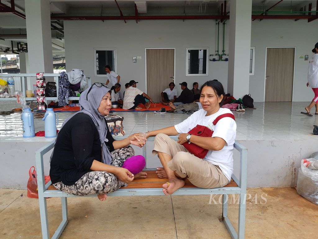 Warga yang dijanjikan untuk menghuni Kampung Susun Bayam duduk mengobrol hingga berbaring di pelataran Kampung Susun Bayam, Jakarta Utara, Selasa (14/3/2023) sore. 