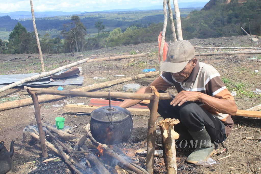 Ketua Kelompok Masyarakat Adat Simenak Henak Mangapul Samosir (68) memasak air minum di hutan adat yang mereka dapatkan kembali setelah sempat menjadi konsesi PT Toba Pulp Lestari di Desa Parsoburan Barat, Kecamatan Habinsaran, Kabupaten Toba, Sumatera Utara, Kamis (16/11/2023). 
