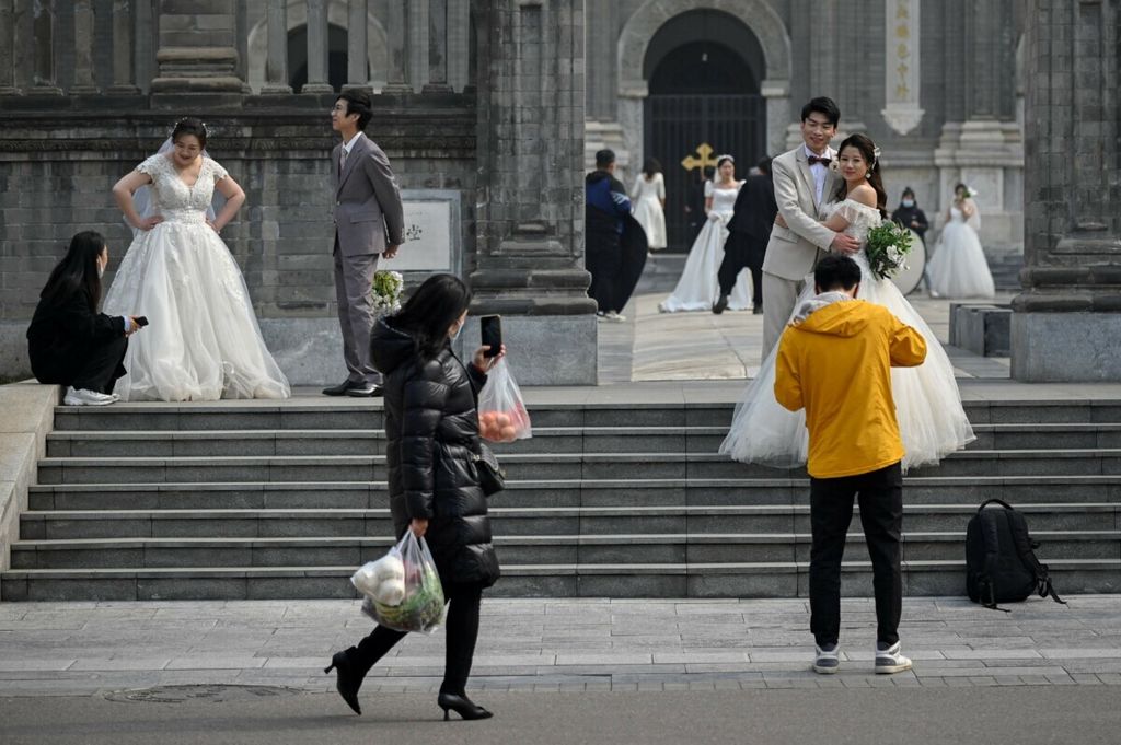 Sejumlah pasangan yang menikah di depan sebuah gereja di Beijing, China, 11 Maret 2021.