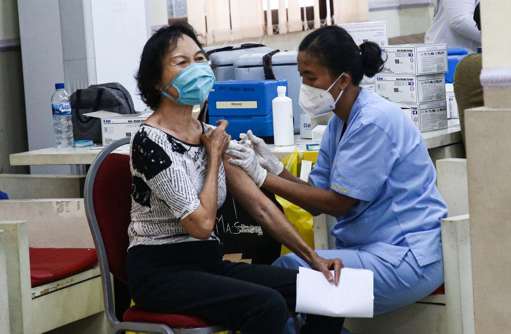 Warga lanjut usia menerima suntikan vaksin Covid-19 ketiga dalam kegiatan vaksinasi massal Covid-19 penguat bagi lansia di Puskesmas Kebon Jeruk, Jakarta Barat, Jumat (14/1/2022). 