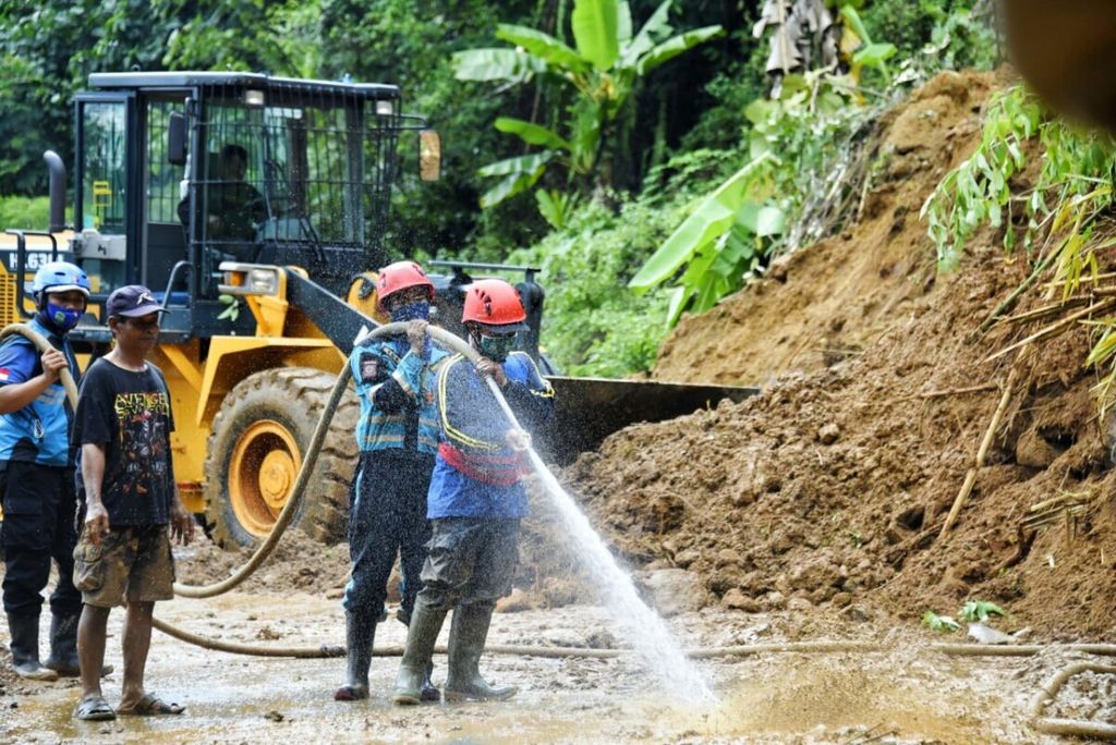 Petugas membersihkan ruas jalan yang teruputus akibat longsor di Kabupaten Tasikmalaya, Jawa Barat, Senin (12/10/2020).