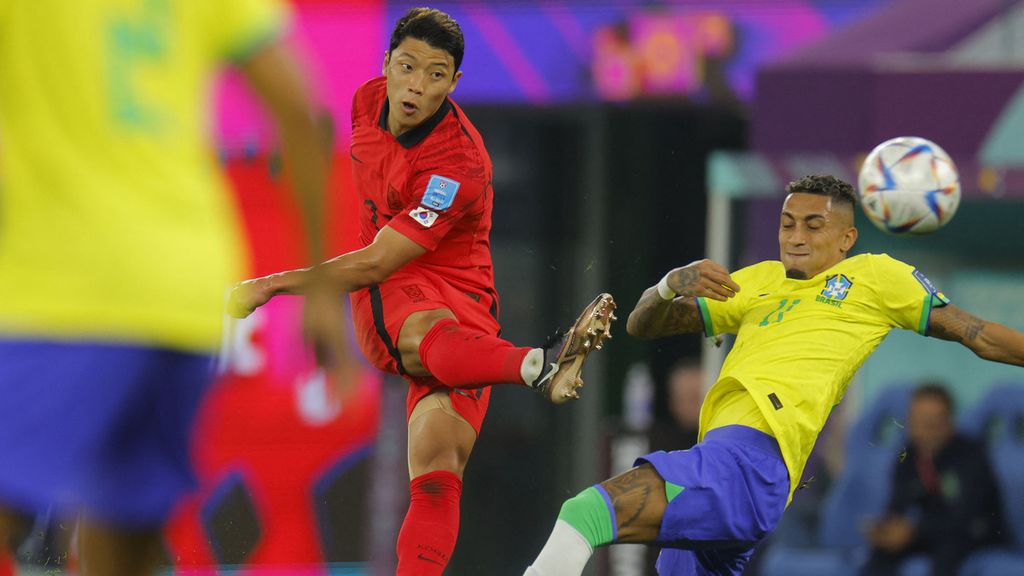Pemain timnas Korea Selatan Hwang Hee-chan (kiri) menendang bola melewati pemain timnas Brasil Raphinha pada babak 16 besar Piala Dunia Qatar 2022 di Stadion 974 Qatar, Senin (5/10/2022). Brasil menang dengan skor 4-1. 
