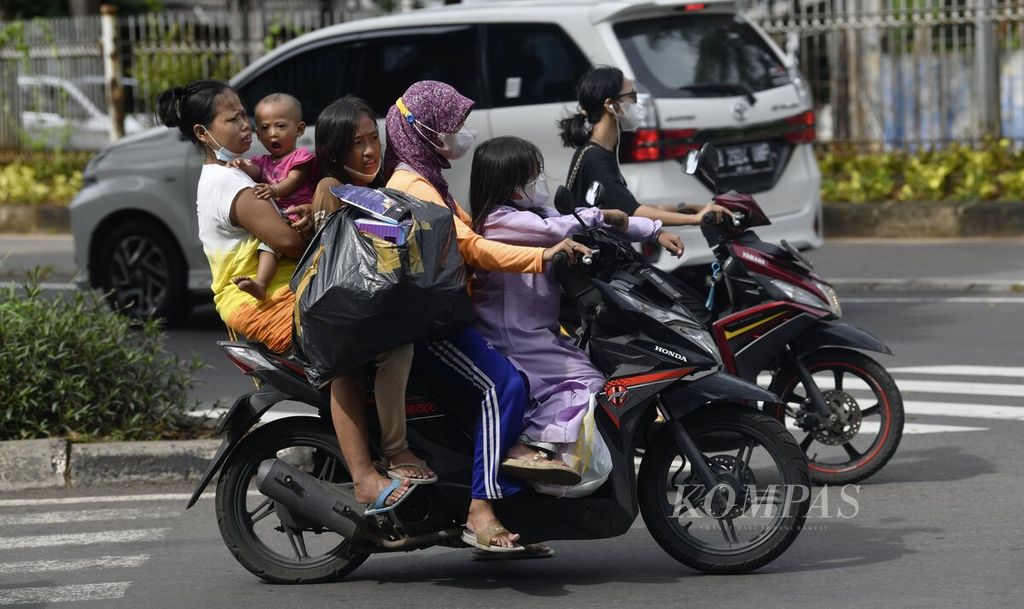 Warga mengendarai sepeda motor berboncengan lima orang di kawasan Kebon Jeruk, Jakarta Barat, Minggu (27/2/2022). Kementerian Dalam Negeri melalui Direktorat Jenderal Dukcapil memperbarui data kependudukan semester II-2021 yang mencatat jumlah penduduk Indonesia adalah 273.879.750 jiwa. 