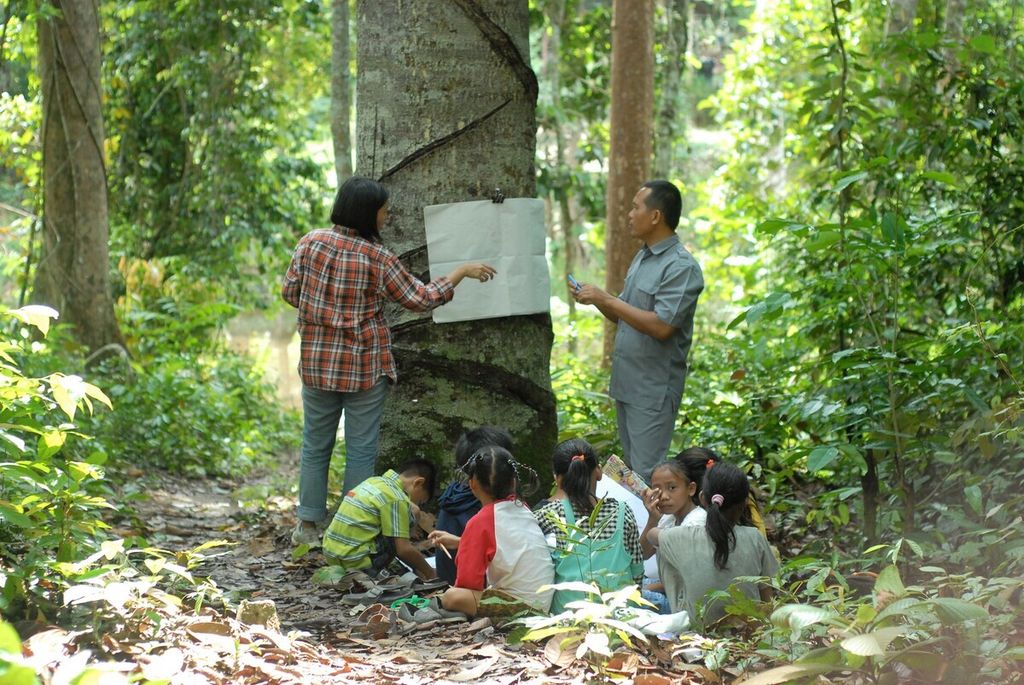 Guru adaptif mengajar anak-anak suku Batin Sembilan di Hutan Harapan, wilayah Kelompang, Kabupaten Batanghari, Jambi, Jumat (26/11/2021).