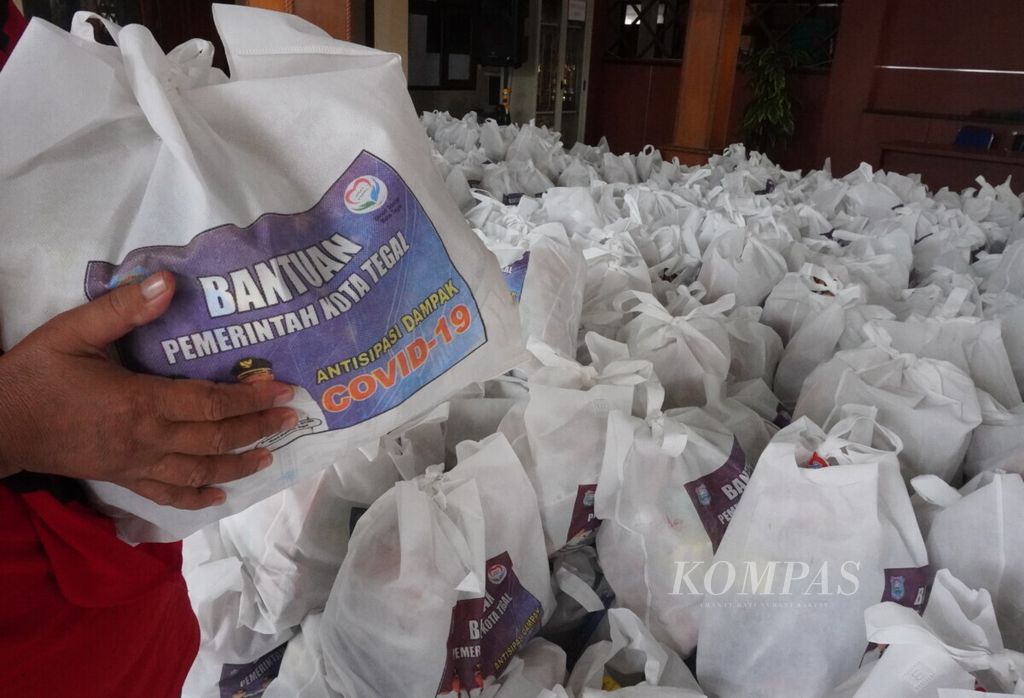 Petugas menunjukkan bantuan paket kebutuhan pokok dari Pemerintah Kota Tegal bagi masyarakat miskin dan terdampak pandemi Covid-19, di Kelurahan Slerok, Kecamatan Tegal Timur, Kota Tegal, Jawa Tengah, Minggu (19/4/2020).