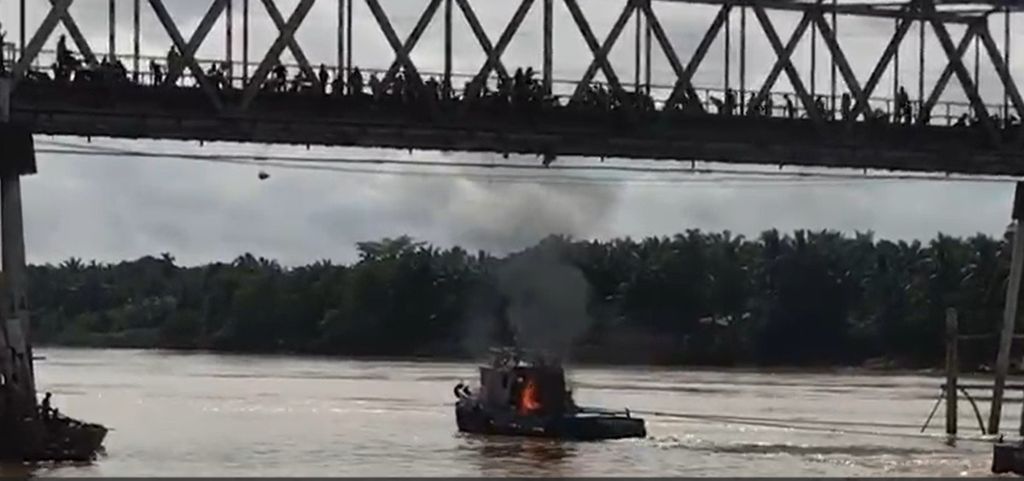 Sebuah <i>tugboat </i>batubara dilempari batu dan molotov oleh massa dari atas Jembatan Pelayangan di Kabupaten Batanghari, Jambi, Kamis (23/5/2024).