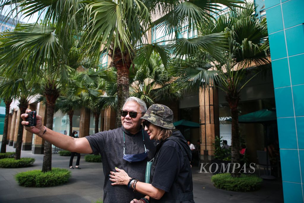 Pasangan suami istri Noorca M Massardi (68) dan Rayni N Massardi (65) berswafoto saat menghabiskan sore berdua di sebuah pusat perbelanjaan di kawasan Senayan, Jakarta Pusat, Selasa (13/9/2022).