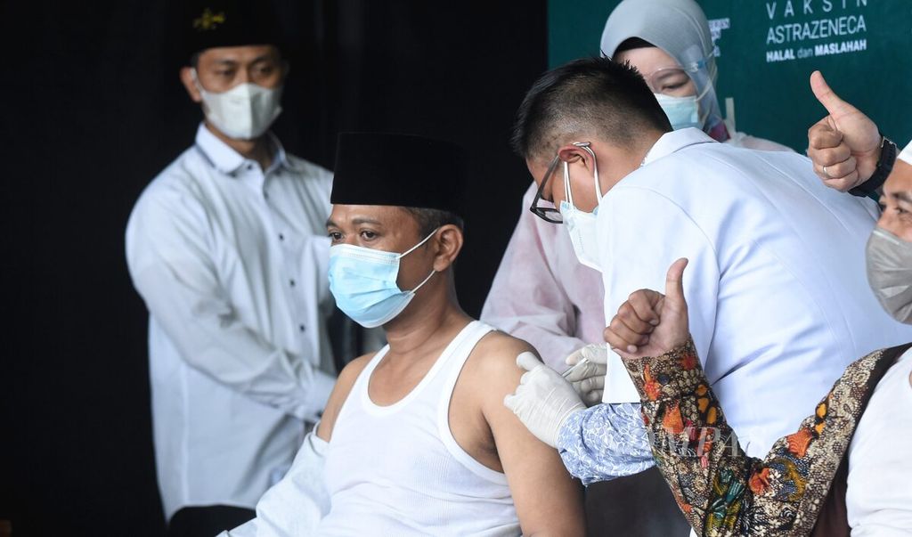 Vaksinator memberikan vaksin AstraZeneca kepada kiai Nahdlatul Ulama (NU) dalam kegiatan vaksinasi yang dihadiri Menteri Kesehatan Budi Gunadi Sadikin di Kantor PWNU Jawa Timur, Surabaya, Selasa (23/3/2021). Pada kesempatan tersebut, sekitar 100 kiai NU di Jawa Timur disuntik vaksin Covid-19 AstraZeneca. 