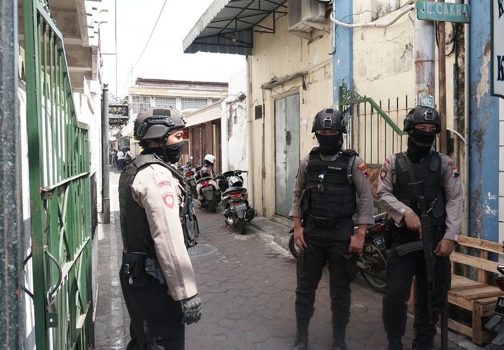 Polisi bersenjata berjaga-jaga saat dilakukan penggeledahan di tempat kos F, terduga teroris di Jalan Cakra, Kauman, Solo, Jawa Tengah, Senin (18/11/2019).