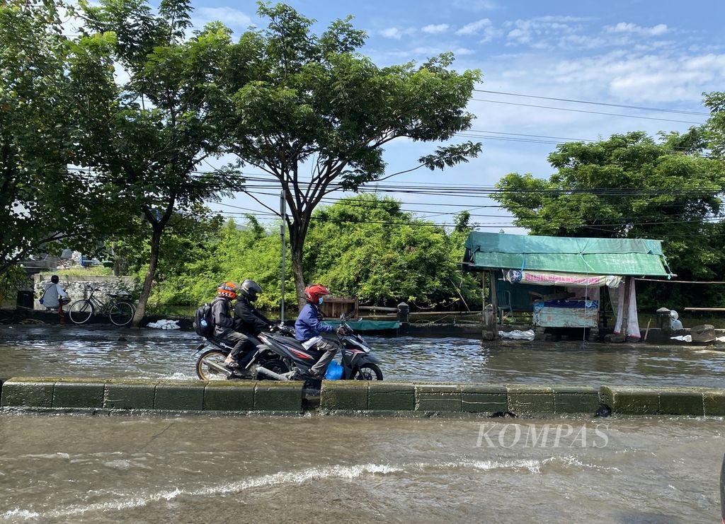 Pemudik menerjang banjir dengan ketinggian 30 sentimeter di Jalan Pantura Kaligawe, Kota Semarang, Jawa Tengah, Senin (8/4/2024). 