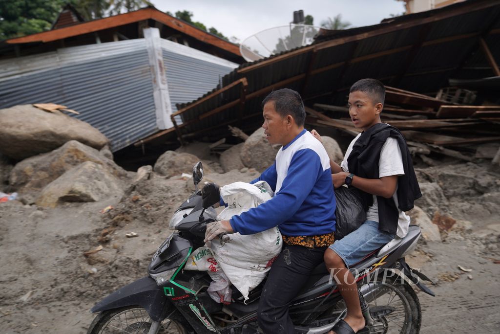 Warga terdampak banjir bandang membawa barang yang masih bisa digunakan di Desa Simangulampe, Kecamatan Baktiraja, Kabupaten Humbang Hasundutan, Sumatera Utara, Kamis (7/12/2023). 