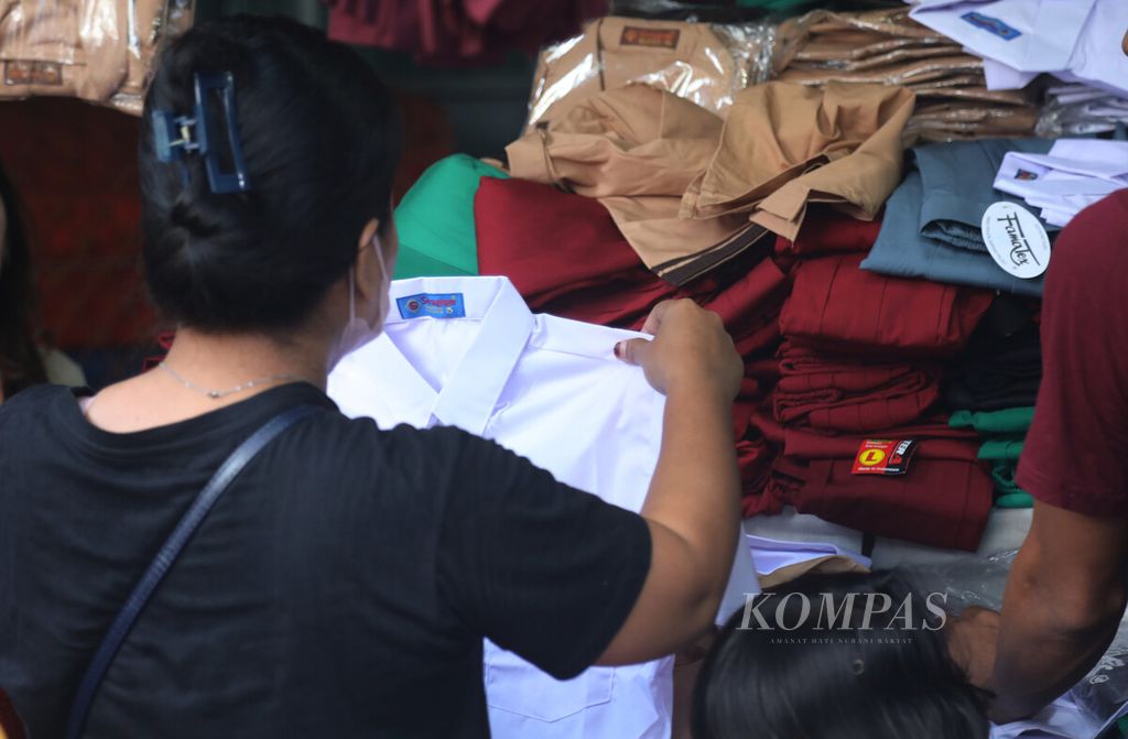 Warga memilh baju seragam di salah satu lapak pedagang di Pasar Jatinegara, Jakarta, Minggu (10/7/2022). 
