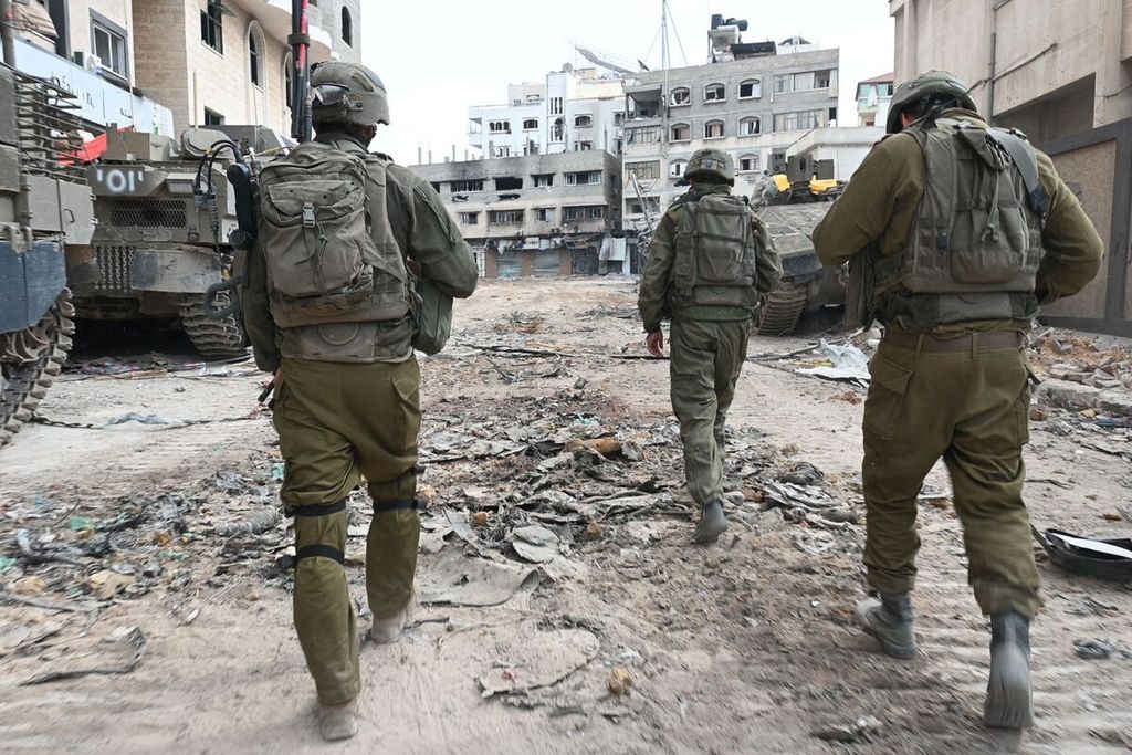 Dalam foto yang diambil saat liputan yang dikontrol dan pemuatannya diedit oleh militer Israel ini terlihat tentara Israel berpatroli di sebuah ruas jalan di Jalur Gaza utara, 22 November 2023, saat berlangsung pertempuran antara Hamas dan Israel. 