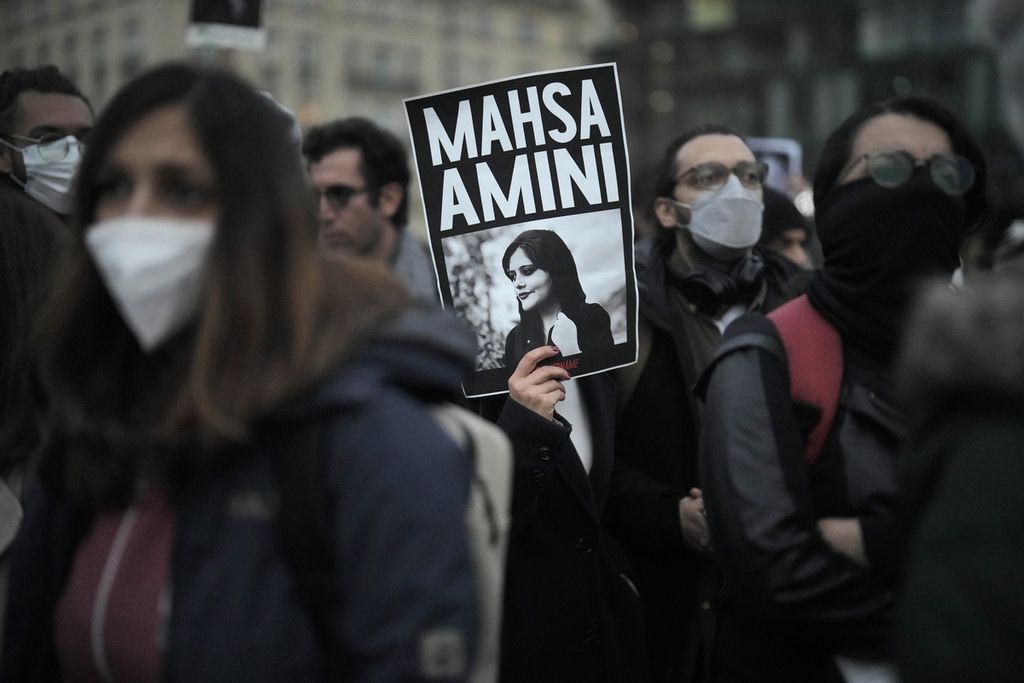 Seorang warga membawa poster foto Mahsa Amini dalam unjuk rasa memprotes kematian Amini di Berlin, Jerman, Rabu (28/9/2022). 