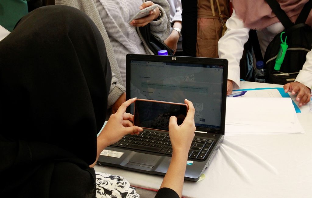 Pencari kerja memindai kode batang tautan layanan kerja di bursa kerja Job Fair MNC Festival, Jakarta, Minggu (3/11/2019). 