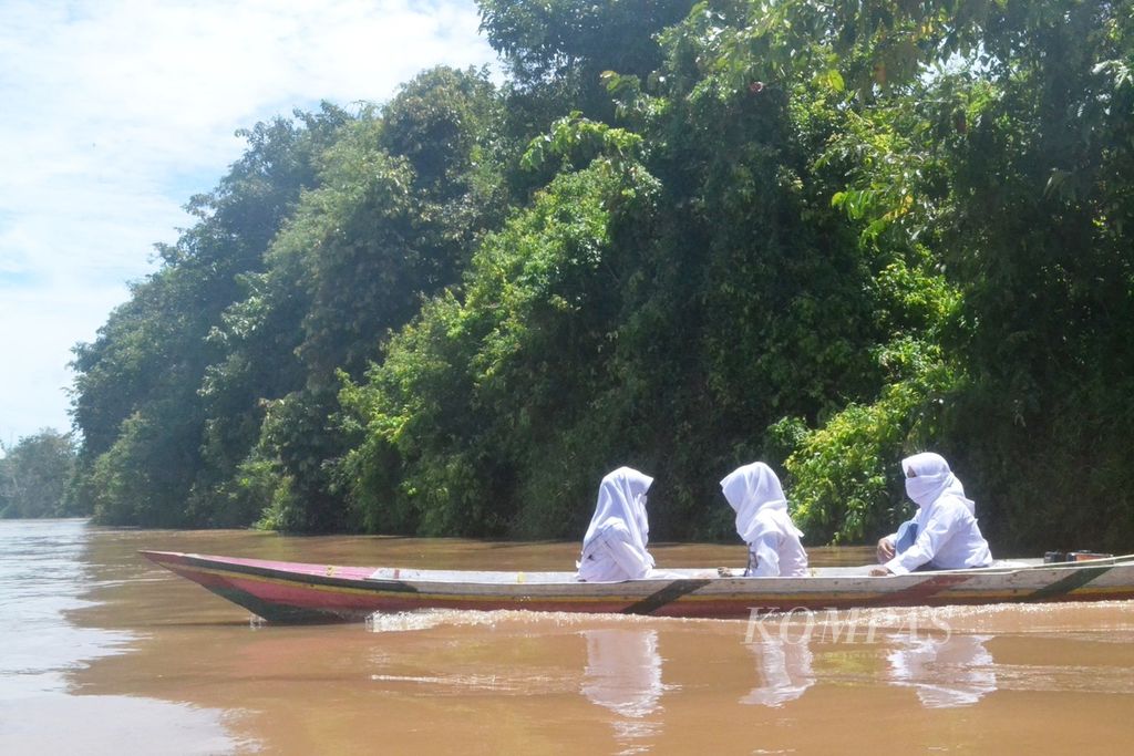 Tiga siswi SMA Negeri 8 Palangka Raya menyusuri Sungai Kahayan, Palangkaraya, Kalimantan Tengah. Mereka menyusuri sungai setiap hari untuk ke sekolah.