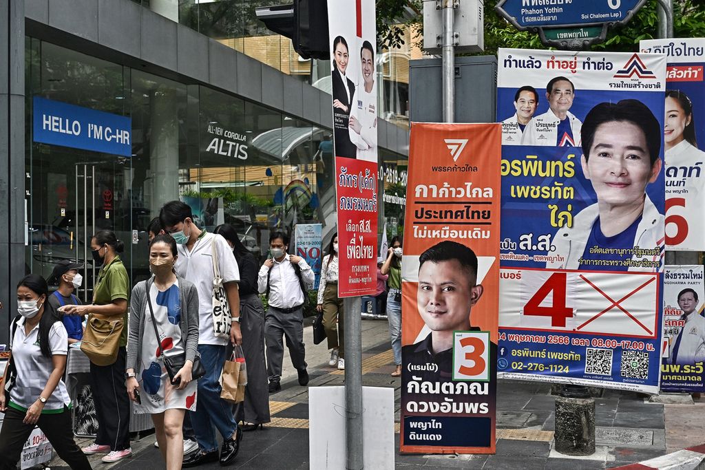 Warga Thailand berjalan melewati berbagai spanduk kampanye partai politik di sepanjang jalan di Bangkok, Thailand, pada 10 Mei 2023, menjelang pemilihan umum Thailand 14 Mei mendatang. 