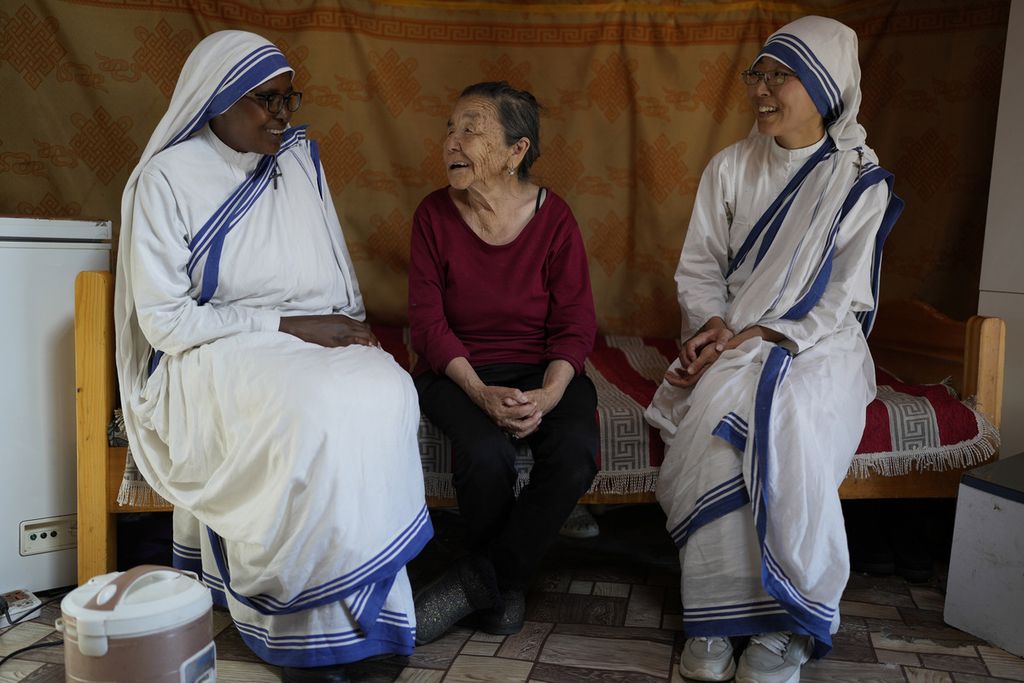 Jeanne Francoise dari Rwanda (kiri) dan Chanmi dari Korea Selatan berbincang dengan lansia saat mereka mengunjungi keluarga yang membutuhkan bantuan dari Missionaries of Charity, sebuah kongregasi wanita Katolik Roma yang didedikasikan untuk orang miskin yang didirikan Bunda Teresa di pinggiran Ulan Bator, Mongolia pada 30 Agustus 2023. 