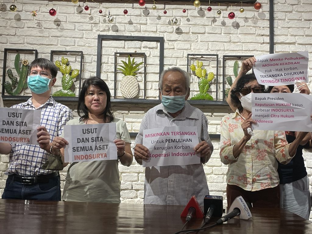 Para korban kasus gagal bayar Koperasi Simpan Pinjam Indosurya menunjukkan poster saat konferensi pers di Jakarta, Minggu (18/12/2022). Mereka menuntut majelis hakim memutuskan agar aset terdakwa yang disita dikembalikan ke mereka alih-alih diserahkan kepada negara.