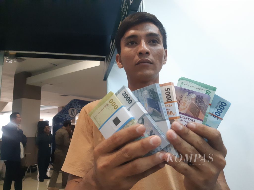 Warga menunjukkan sejumlah uang yang telah ditukarkan di Grage City Mall, Kota Cirebon, Jawa Barat, Senin (25/3/2024).